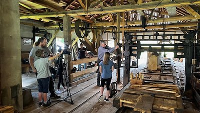 The children are shown how the historic sawmill works. -